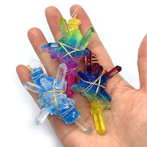 Three handmade wire wrapped natural aura quartz crystal pendants shown in hand for scale
