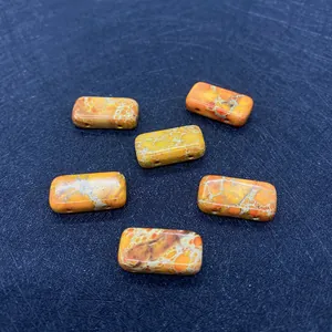 Dettaglio di perle rettangolari in pietra imperatore arancione con doppi fori per fai da te