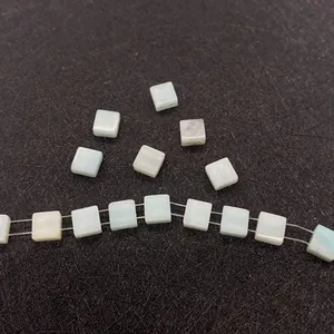 Vista detallada de cuentas cuadradas de amazonita azul con doble agujero para joyería DIY