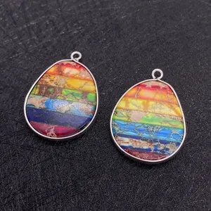 Detailopname van kleurrijke regenboog keizersteen druppelhangers met zilveren rand