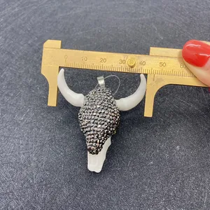 Messung des 42-mm-Acryl-Stierschädel-Anhängers mit Strasssteinen und einem Messschieber