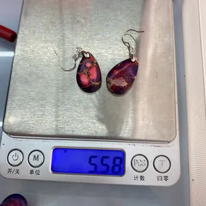 Makroaufnahme bohämischer lila Steinohrringe in Tropfenform, 5,58g auf einer Digitalwaage