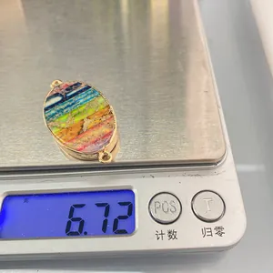Detailed macro view of oval natural stone connector with gold plating on digital scale