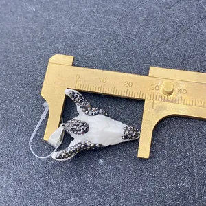 Macro detail of acrylic bull skull pendant width measurement with vernier caliper