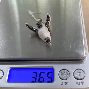 Macro detail of a bull head pendant with black crystals on a scale weighing 3.65g