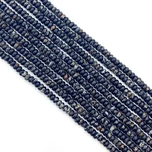 Gros plan de perles rondelles en pierre impériale noire avec motifs marbrés pour bijoux DIY