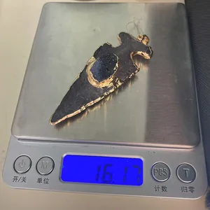 Pendentif en forme de flèche avec cristal bleu pesé sur une balance numérique