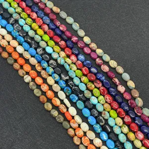 Dettaglio macro di perle ovali in diaspro di vari colori per creazione di gioielli