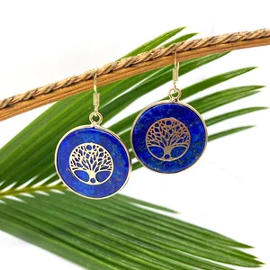 Blue lapis lazuli round earrings with gold tree of life charms hanging on a branch