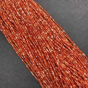Macro shot of faceted carnelian beads in vibrant shades of orange and deep red