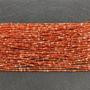 Macro detail of faceted red agate beads with high-shine surface for DIY jewelry making