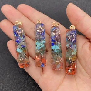 Macro view of four Orgone energy resin pendants with crushed stones held in hand
