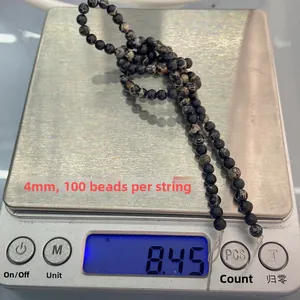 Détail macro de perles en pierre naturelle de 4mm pesant 8,45g sur une balance digitale