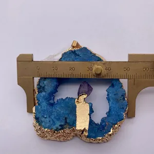 Macro-opname van blauwe kristal hanger met gouden rand en breedte van circa 48mm