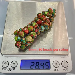 Balance numérique affichant 28,45g pour un fil de 50 perles de pierre impériale de 8mm
