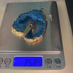 Detailopname van blauwe agaat hart hanger met paars kristal op een weegschaal