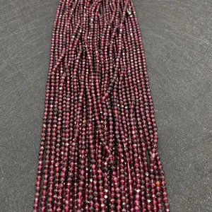 Gros plan de perles de grenat facettées rouge foncé pour la création de bijoux DIY