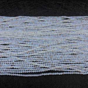 Macro detail of 2mm faceted light blue opal beads showing translucent polished texture
