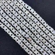 Macro detail of white pearl shell beads in Triomphe shape for DIY jewelry making