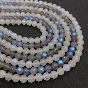 Nahaufnahme runder Mondsteinperlen mit blauem Schimmer und irisierendem Labradoreszenz-Effekt