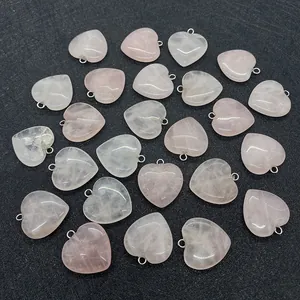 Macro view of several heart-shaped rose quartz crystal pendants with metal ring connectors