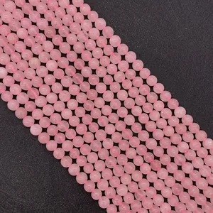 Detailed macro view of natural rose quartz round beads with smooth surface and ice cracks