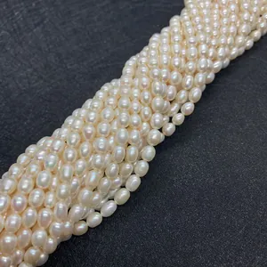 Vue macro de perles d'eau douce naturelles AAA de forme riz avec éclat doux sur tapis noir