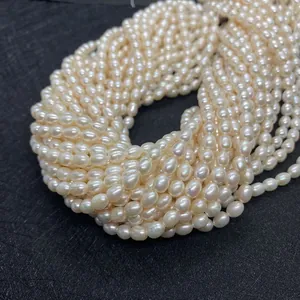 Détail macro de perles de culture d'eau douce blanches forme de riz sur tissu noir texturé