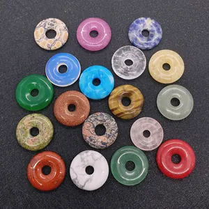 Detailed view of 20mm round donut-shaped natural stone pendants in various colors and textures