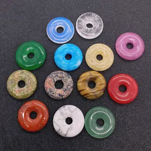 Detailed view of various colorful natural stone donuts including agate and tiger eye for DIY