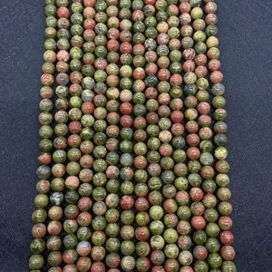 Detailed view of natural Unakite stone beads arranged in rows for jewelry making