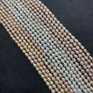 Macro shot of colorful oval freshwater pearls in white pink and lilac on black background