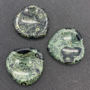 Détail macro de trois pierres de malachite verte en forme de cœur aux textures naturelles