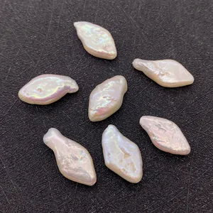 Macro detail of irregular baroque pearls with shimmering pink luster on dark background