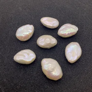 Détail de sept perles d'eau douce baroques aux reflets irisés sur fond noir texturé