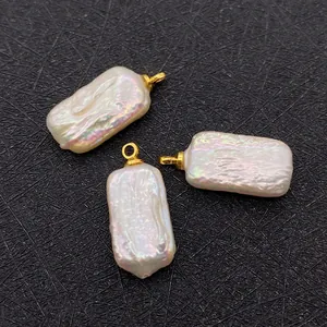 Macro shot of three baroque rectangular freshwater pearls with golden ring clasps