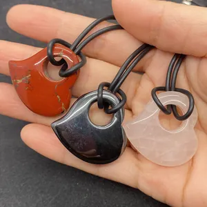 Gedetailleerde weergave van hartvormige natuurstenen hangers met koorden in drie kleuren