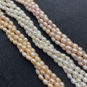 Strands of natural white and pink rice-shaped freshwater pearls on a dark background