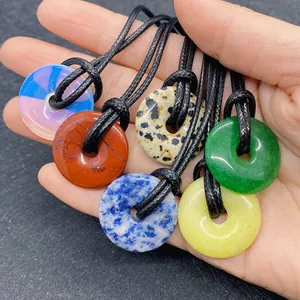 Detailed close-up of colorful round tiger eye stone pendants with black woven cords