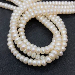 Macro close-up of high-luster freshwater pearl strands on a black textured background