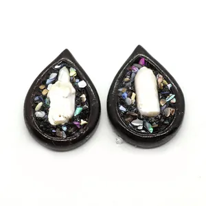 Vue macro de pendentif goutte en résine avec perle incrustée et détails en coquillage
