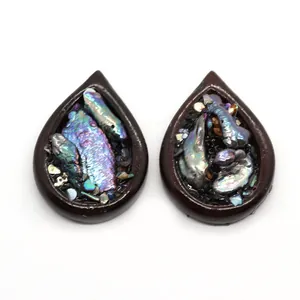 Détail macro de pendentifs en forme de larme avec nacre d'abalone et bordure texture bois