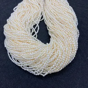 Macro de perles d'eau douce blanches forme riz 2-3mm sur fond textile noir