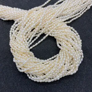 Perles d'eau douce naturelles 2-3mm blanc crème sur un fond sombre texturé de luxe