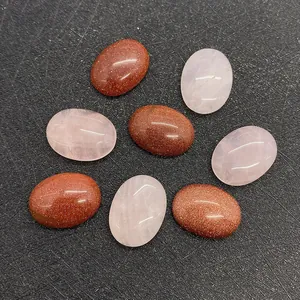 Detailed macro view of oval-shaped goldstone and rose quartz cabochons for DIY jewelry