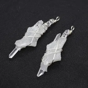 Detail of natural white crystal pendants with silver wire wrapping on dark background