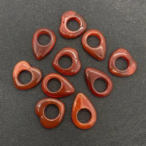 Macro view of natural red agate heart and waterdrop pendants with large holes for jewelry DIY