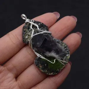 Macro detail of handmade wire wrapped raw amethyst stone pendant with silver metal wire