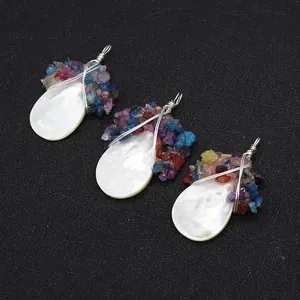 Detail van drie met zilverdraad omwikkelde schelphangers met kleurrijke edelstenen
