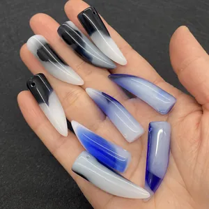 Macro shot of eight claw-shaped agate stone pendants with polished blue and black gradients
